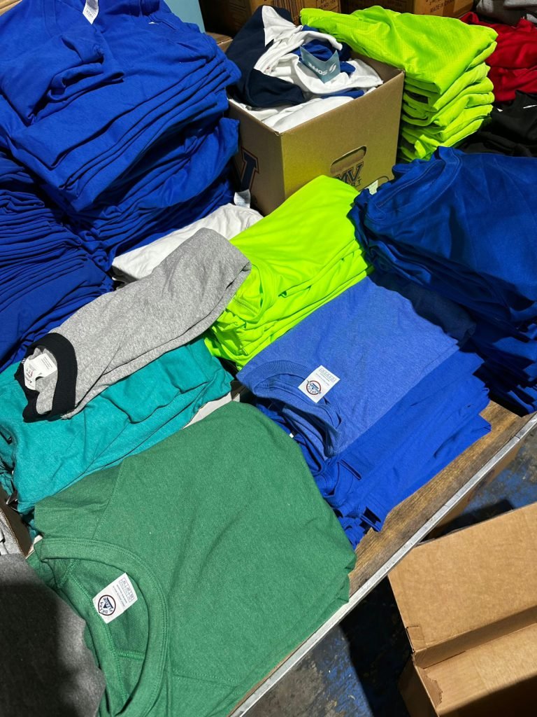 Wholesale Lot Of 100,000 T-Shirts, Tank Tops, Sweatshirts, And Muscle Tees By Delta, Soffe, And Ron Jon Surf Shop – 20% Men’s, 40% Women’s, 40% Kids – First Quality – No Manifest – Only .35 Each